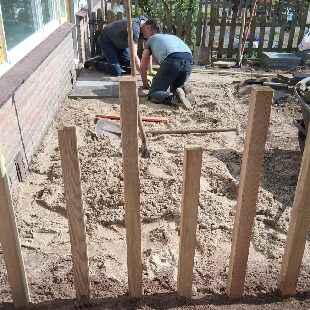 Vrijwilligers leggen het nieuwe terras aan met hergebruikte tegels