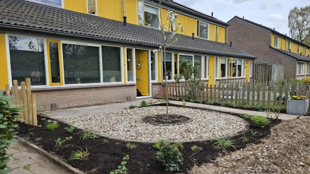 Overzicht van de voortuin in Apeldoorn direct na de aanleg met verse aarde en de jonge boom